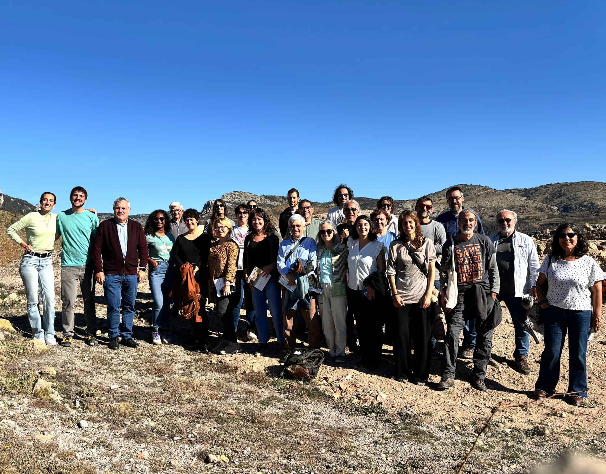 Fotografía de las personas participantes en el encuentro, junto a los restos del castillo de Bejis.